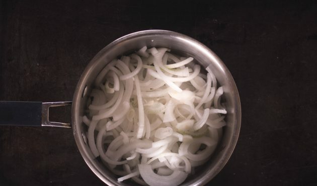 Tarta gruszkowa z karmelizowaną cebulą i fetą: włożyć cebulę do rondla i podsmażać na średnim ogniu