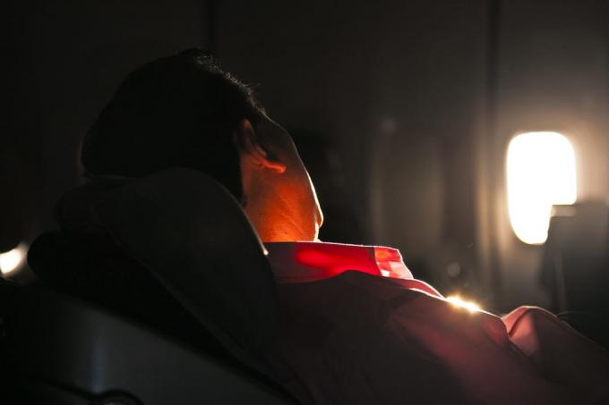 Człowiek śpi w fotelu samolotu w Sunrise